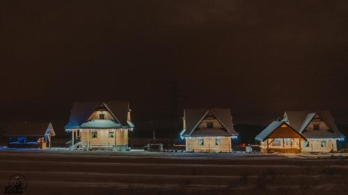 a row of houses at night with snow on the roofs at Domki Szarotki in Groń