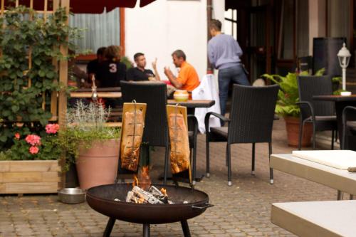 a fire pit in a restaurant with people sitting at tables at Hotel Zum Löwen in Mörfelden-Walldorf