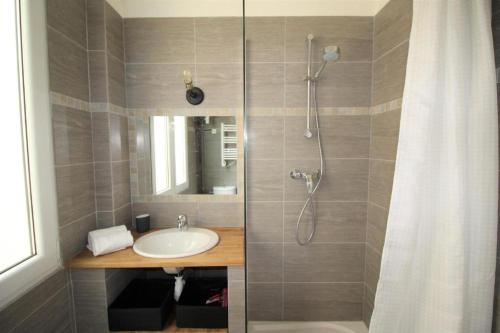 La salle de bains est pourvue d'un lavabo et d'une douche avec rideau de douche. dans l'établissement Nice Renting - NOTRE DAME - Cosy Loft Perfect View on the roofs, à Nice