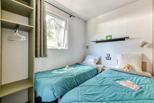 سرير أو أسرّة في غرفة في Camping maeva Escapades Millau Plage