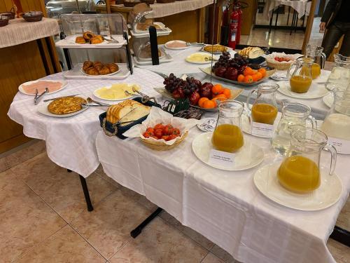 a table with plates of food and fruit on it at HOTEL FESTA BRAVA in Andorra la Vella