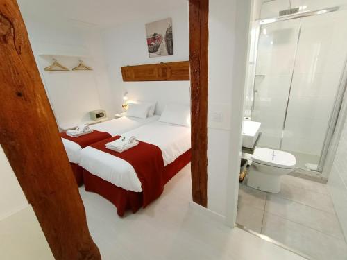 1 dormitorio con 1 cama y baño con aseo en Hostal Royal Cruz, en Madrid