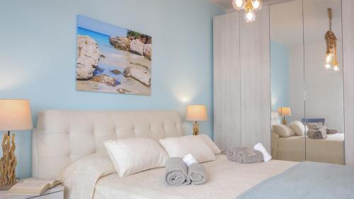 Un dormitorio con una gran cama blanca con toallas. en Dimora Paradiso, Monopoli, Puglia, Sea-View, Stylish, Family Friendly Home, en Monopoli