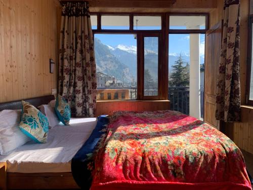 a bedroom with a bed with a view of a mountain at Tourist Hotel 10 minutes walking distance from the mall in Manāli