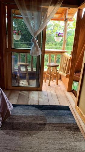 a room with a door open to a porch with two stools at CABAÑA LOS NOGALES in San Agustín