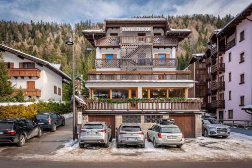 a large building with cars parked in a parking lot at Hotel Italo in Madonna di Campiglio