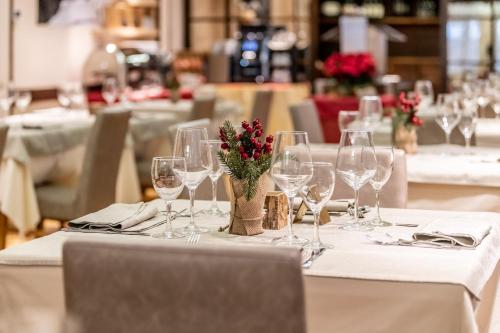un tavolo con bicchieri da vino e fiori di Hotel Italo a Madonna di Campiglio