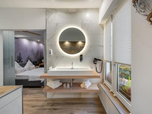 a bathroom with a sink and a bed in a room at Cityhotel Bernburg in Bernburg