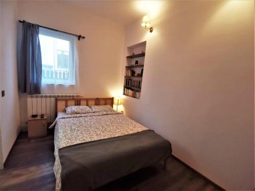 a small bedroom with a bed and a window at Casa Bunicilor Sinaia in Sinaia