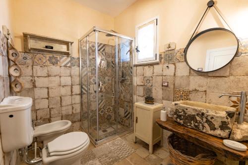 uma casa de banho com um chuveiro, um WC e um lavatório. em Fiorillo Cottage em Gagliano del Capo