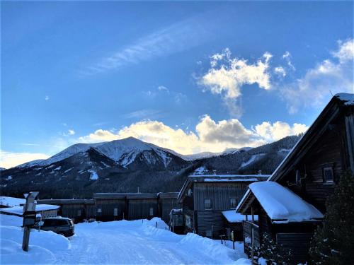 a snow covered village with mountains in the background at EXCLUSIVES Chalet an der SKIPISTE +Dampfbad +NETFLIX in Hohentauern