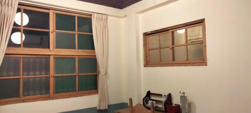 台南的住宿－新東亞旅埕，客房设有窗户和带微波炉的桌子。