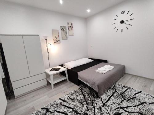 a bedroom with a bed and a clock on the wall at Apartament Sikorki in Nowy Sącz