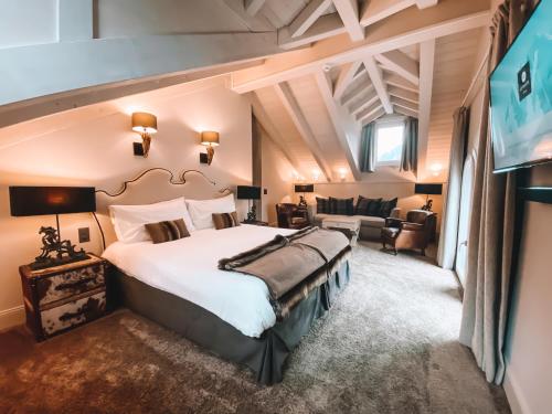 ein Schlafzimmer mit einem großen Bett und einem TV in der Unterkunft Hôtel Le White - Le 42 Restaurant in Champéry