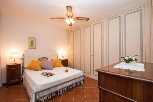 a bedroom with a bed with yellow and purple pillows at Le Ortensie 1 Apartment by Wonderful Italy in Soiano del Lago