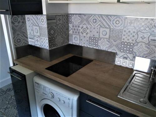 - une cuisine avec un comptoir et un lave-linge dans l'établissement studio climatisé et calme, proche centre et mer, à Mandelieu-la-Napoule