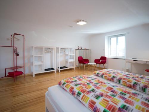 a bedroom with two beds and two red chairs at Gästehaus zur Griechswies in Losheim