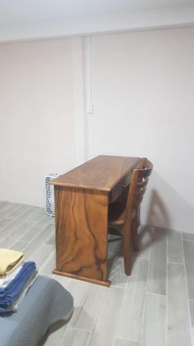 a wooden table and a chair sitting in a room at Hogar tico-estadounidense cerca de aeropuerto in Alajuela City