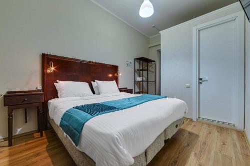 a bedroom with a large bed with a wooden headboard at House 52 Boutique Hotel in Tbilisi City