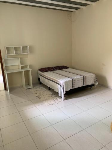 une chambre avec un lit dans le coin d'une pièce dans l'établissement Casa Temporada na Praia do Peró, à Cabo Frio