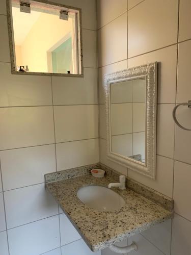 une salle de bain avec un lavabo et un miroir dans l'établissement Casa Temporada na Praia do Peró, à Cabo Frio