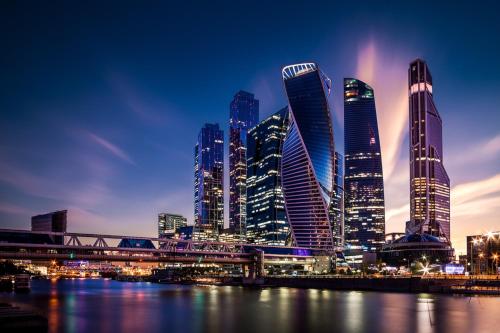 a city skyline with tall buildings at night at Park Hotel Fili in Moscow