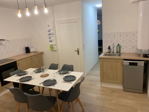 une cuisine avec une table et des chaises dans une cuisine dans l'établissement L EFFET MER 70M2 avec 2 chambres doubles avec Parking 1 voiture GRATUIT, Netflix Disney plus disponible Lits faits à l arrivé Serviettes de toilettes fournies, à Dieppe