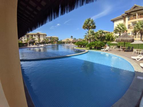 a pool at a resort with chairs and umbrellas at VG Sun Cumbuco Sea Breeze Vista Mar in Cumbuco
