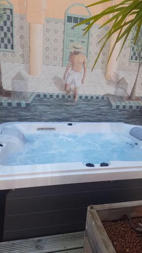 une baignoire avec un homme assis dans l'établissement La Maison de L Artiste - Chambres d'hôtes à Verdun - avec jacuzzi, à Verdun-sur-Meuse