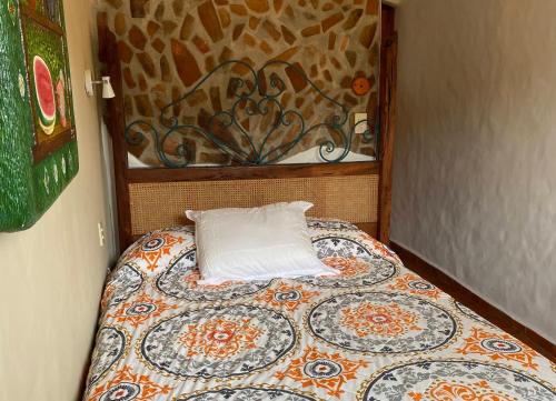 a bed with a pillow on it in a room at Casa Miguel Arcangel in Coatepec