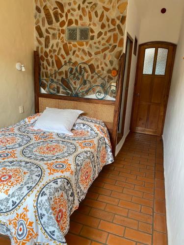 a bedroom with a bed and a stone wall at Casa Miguel Arcangel in Coatepec