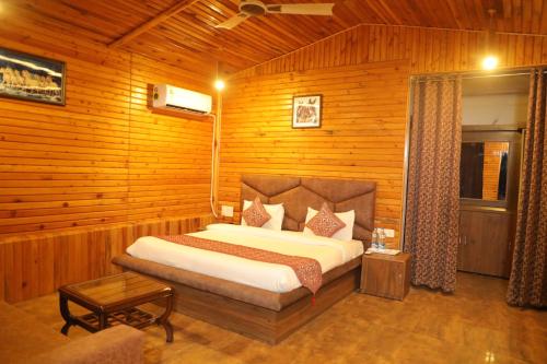 a bedroom with a large bed in a wooden room at HOA Resorts - Mountain View with Infinity Pool in Shivpuri