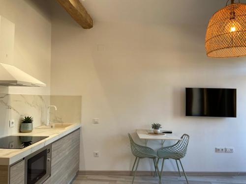eine Küche mit einem Tisch und 2 Stühlen sowie einem TV in der Unterkunft Apartamento Casa Anselmo La cambra 