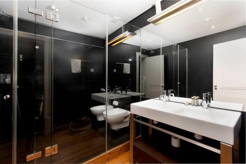 a bathroom with a sink and a toilet and a mirror at Dockside Apartment by Innkeeper in Lisbon