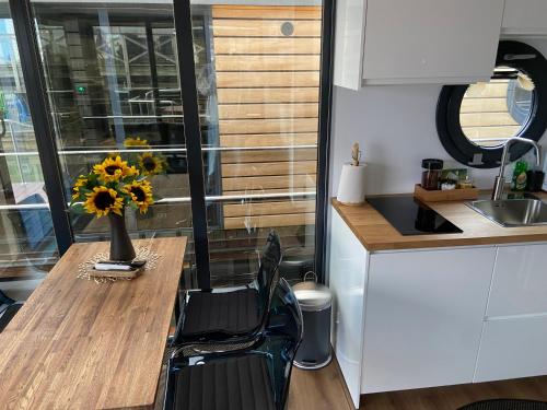 a kitchen with a table with a vase of flowers on it at La Mare Resort in Gothenburg