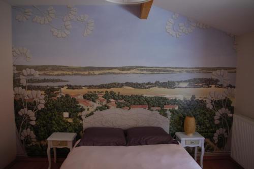 1 dormitorio con una pintura en la pared en La Maison de L Artiste - Chambres d'hôtes à Verdun - avec jacuzzi, en Verdún