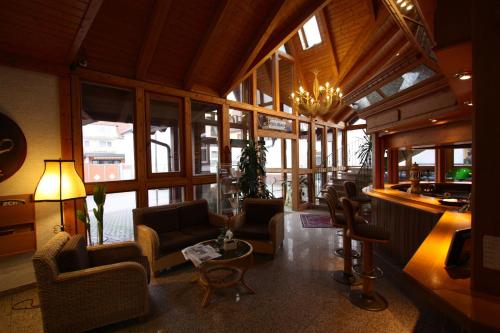 a living room with chairs and a table and windows at Hotel Zum Löwen in Mörfelden-Walldorf