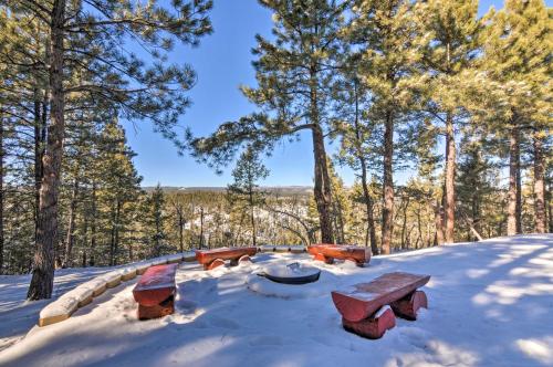 a picnic table in the snow in the woods at Longview Lodge with Furnished Deck and Fire Pit! in Alton