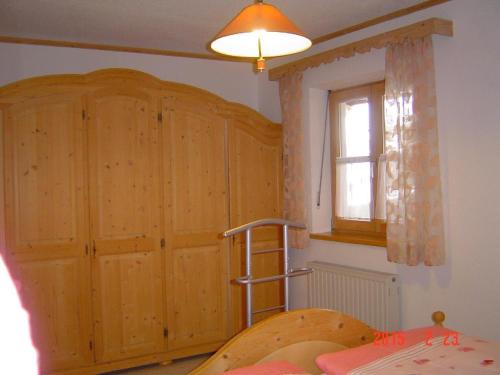 una camera da letto con armadio in legno e scala di Ferienwohnung-im-Haus-Christine a Riedlhütte