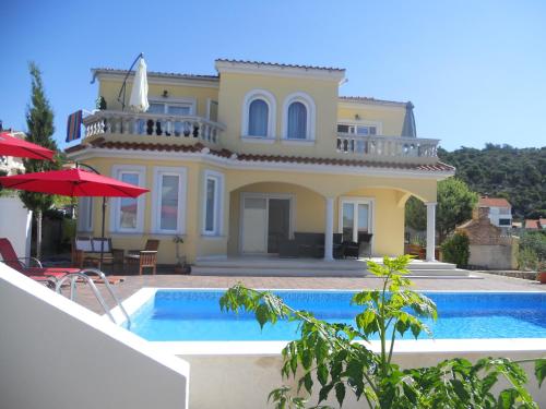 a large house with a swimming pool in front of it at Villa Rosana in Rab