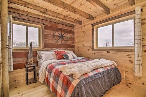 Un dormitorio con una cama en una cabaña de troncos en Serene Views Quiet Farmhouse Cabin in Wisconsin!, en Blanchardville