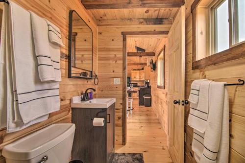 Un baño con inodoro y lavabo en una cabaña de madera. en Serene Views Quiet Farmhouse Cabin in Wisconsin!, en Blanchardville