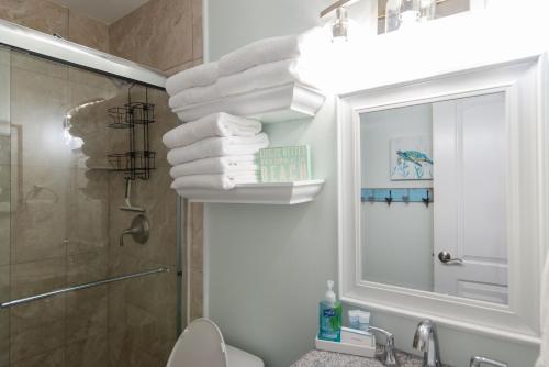 baño con ducha y un montón de toallas en Grand Beach Resort Penthouse 1, en Gulf Shores