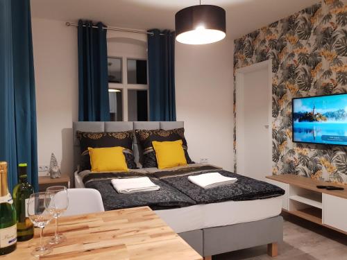 um quarto com uma cama com almofadas amarelas e uma mesa em Apartament Przy Placu Piastowskim em Jelenia Góra