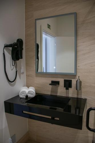 a bathroom with a sink and a mirror at 5ª Vigia in Porto de Mós