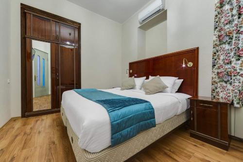 a bedroom with a large bed with a wooden headboard at House 52 Boutique Hotel in Tbilisi City