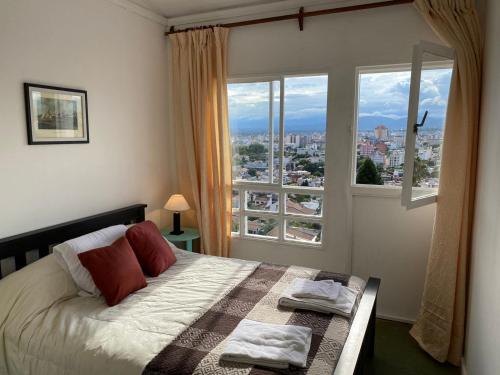 a bedroom with a bed and a large window at Balcones de Salta in Salta