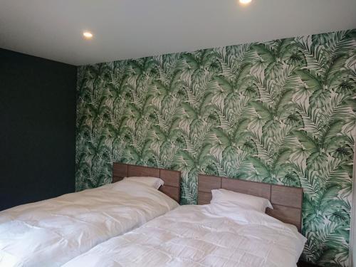um quarto com uma cama e um papel de parede verde e branco em MAHALO - Vacation STAY 05513v em Saikai