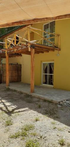 a yellow building with a porch and a window at Balcon de Antares in Uspallata