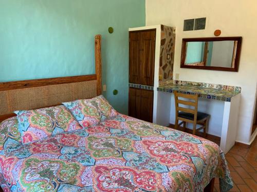 a bedroom with a bed and a mirror and a chair at Casa Miguel Arcangel in Coatepec
